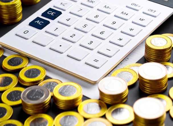 calculadora com moedas de um real ao redor