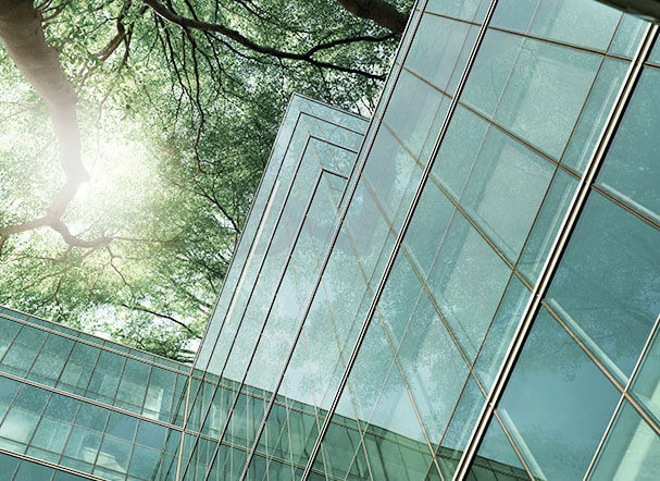 Bottom view of mirrored building with tree in the background